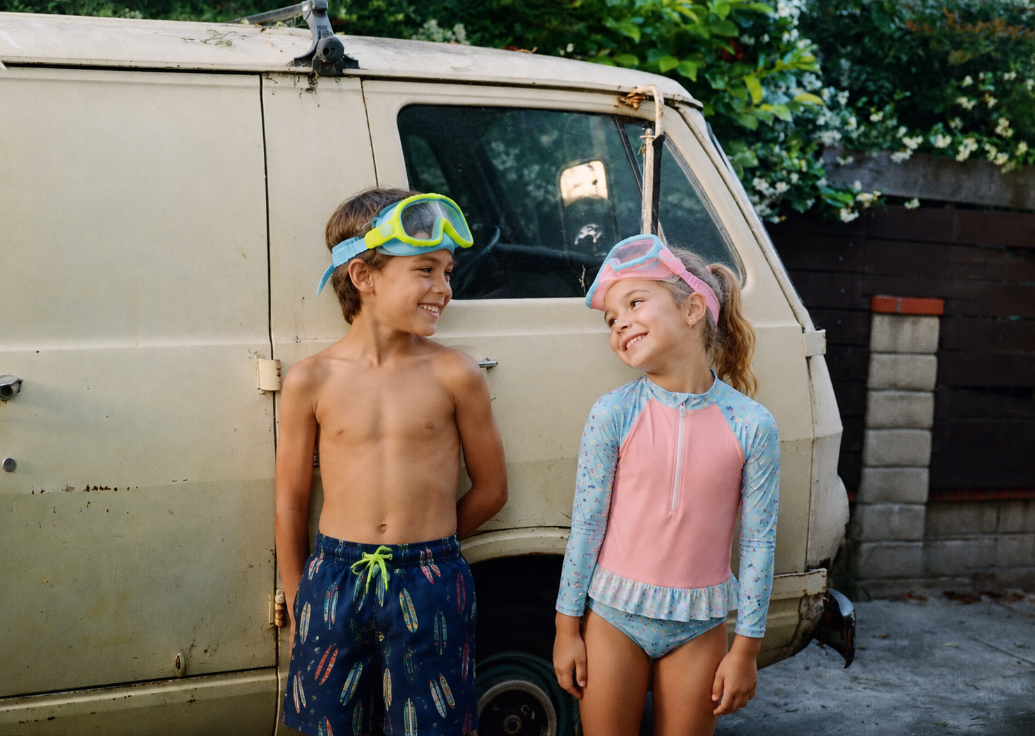 Two kids smiling in Lakeday swim goggles by the lake