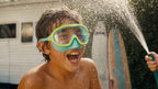 Child laughing in a Lakeday enclosed-nose swim mask during a water spray