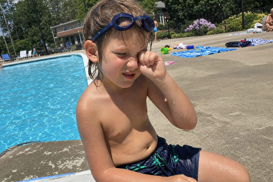 Child rubbing an irritated eye after swimming in ordinary goggles